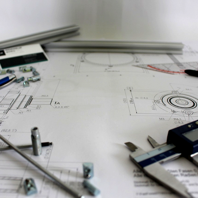 Printouts of a part design on a worktable.